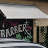 Esplosione davanti al barber shop a Tor Bella Monaca: negozi e palazzo colpiti, crescente allarme tra commercianti e residenti